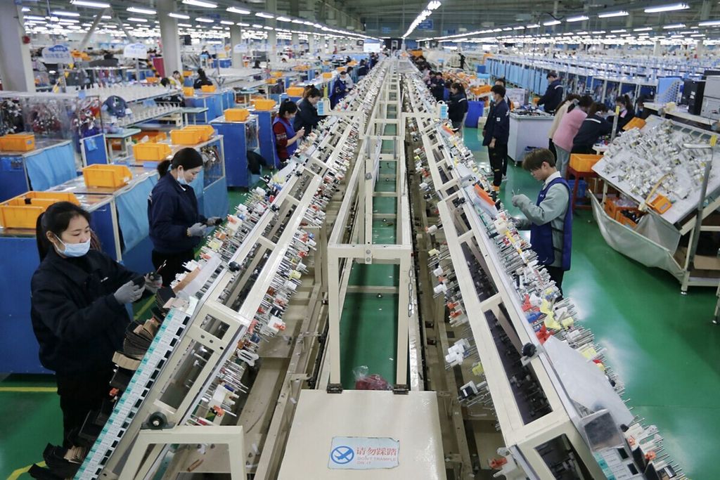 Para karyawan bekerja di bagian produksi kabel di sebuah pagrik, yang memasok sebagian besar aksesoris untuk pasar otomotif luar negeri di Huaibei, Provinsi Anhui, China timur, 9 Maret 2021. 