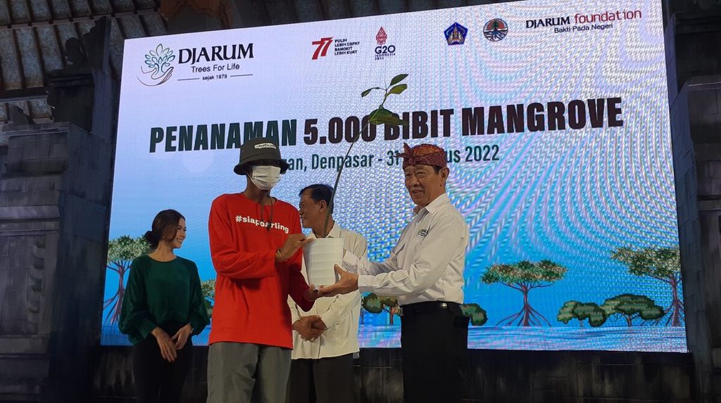 VP Director Djarum Foundation FX Supanji (kanan) menyerahkan bibit mangrove kepada perwakilan komunitas Sadar Lingkungan menjelang kegiatan penanaman bibit mangrove di kawasan Tahura Ngurah Rai di wilayah Pemogan, Denpasar Selatan, Kota Denpasar, Rabu (31/8/2022). 