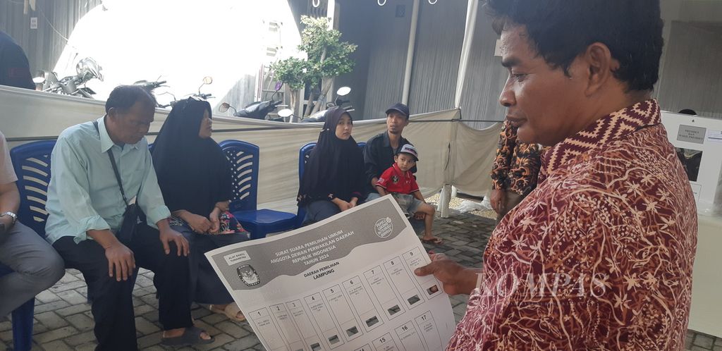 Petugas KPPS memberikan surat suara yang telah dilengkapi alat bantu Braille pada Yatimin (60), pemilih disabilitas yang menyalurkan hak suara di TPS 19 Kelurahan Gunung Terang, Kecamatan Langkapura, Kota Bandar Lampung, Lampung, Rabu (14/2/2024). 