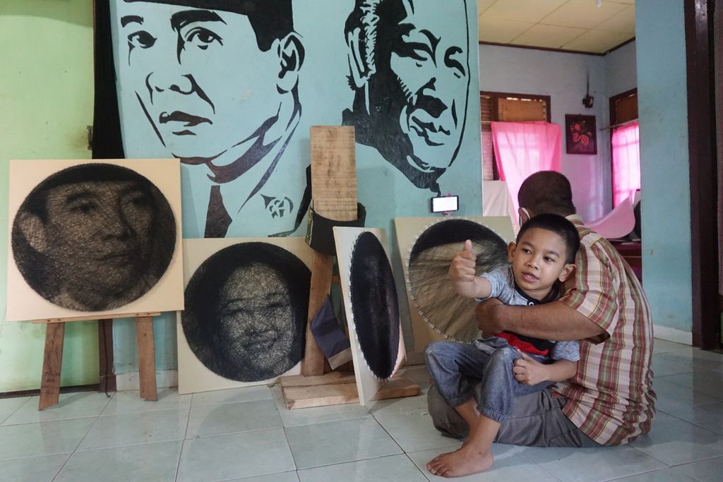 Surip (45), pegiat <i>string art</i> , sedang mengerjakan karya seni dari benang dan paku di rumahnya yang terletak di Desa Haduyang, Kecamatan Natar, Kabupaten Lampung Selatan, Lampung. Minggu (14/3/2021).