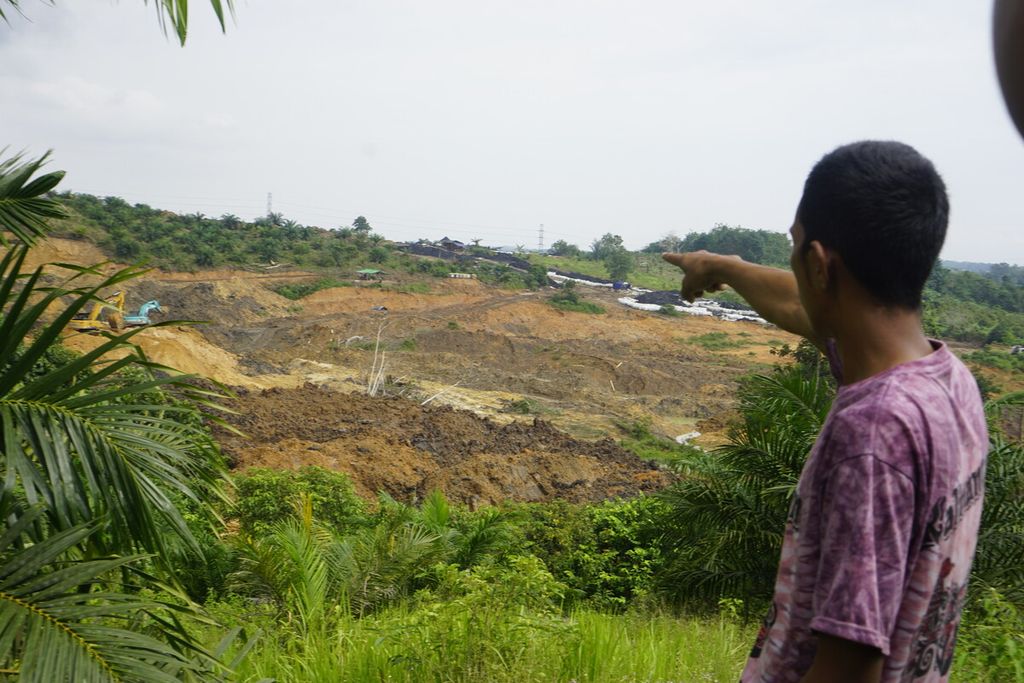 Irwan (42) menunjuk daerah yang dikeruk oleh petambang ilegal di Kecamatan Samboja, Kutai Kartanegara, Kalimantan Timur, Jumat (11/3/2022). Aktivitas tambang itu dihentikan polisi pada akhir September 2022.