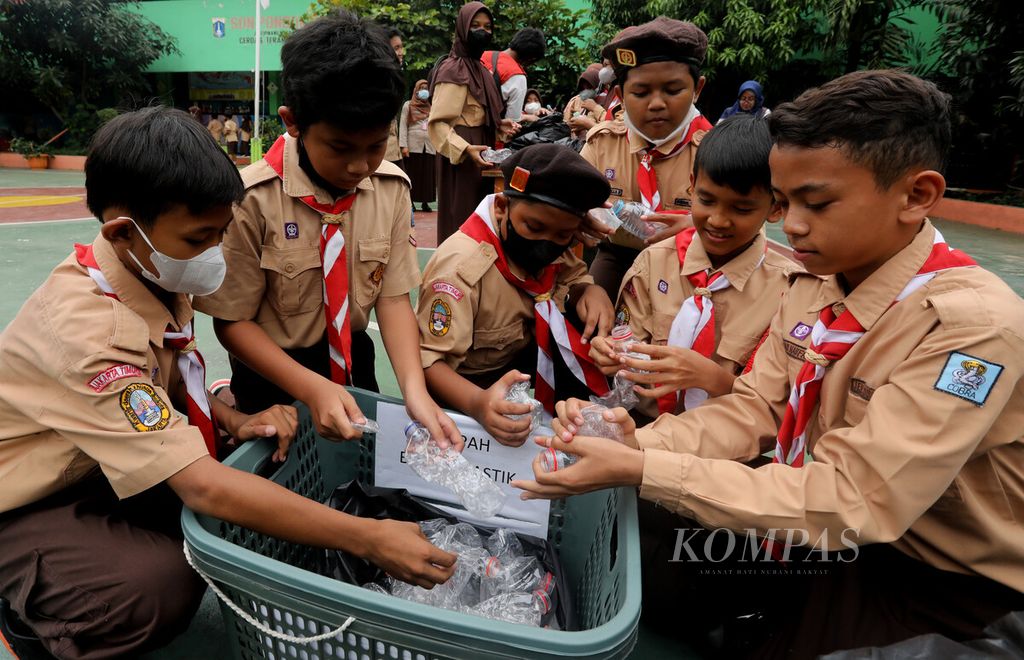 Siswa SDN 04 Pondok Bambu, Jakarta, memilah sampah botol plastik yang telah dipres di halaman sekolah mereka, Rabu (19/10/2022). Sampah tersebut selanjutnya akan diambil oleh petugas dari Bank Sampah Gunung Emas Pulo Kambing.