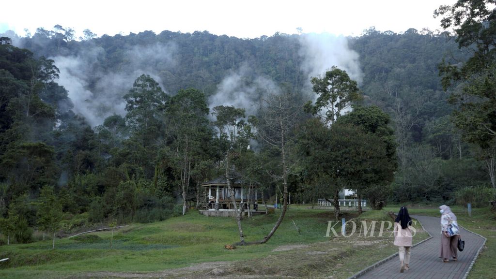 Wisatawan menikmati pesona semburan uap panas dari salah satu kawah di kawasan Wisata Kawah Kamojang, Kabupaten Bandung, Jawa Barat, Rabu (29/9/2021). Kawasan yang berada di Gunung Kamojang ini kaya akan sumber panas bumi yang dimanfaatkan untuk obyek wisata dan pembangkit listrik.