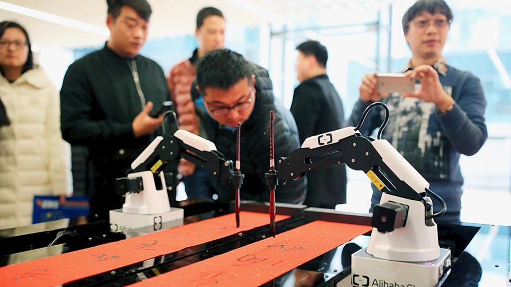 Karyawan Alibaba memperhatikan robot berteknologi kecerdasan buatan, ET, yang sedang menulis bait sajak dalam Festival Musim Semi, di Hangzhou, Provinsi Zhejiang, China, 16 Januari 2017. 