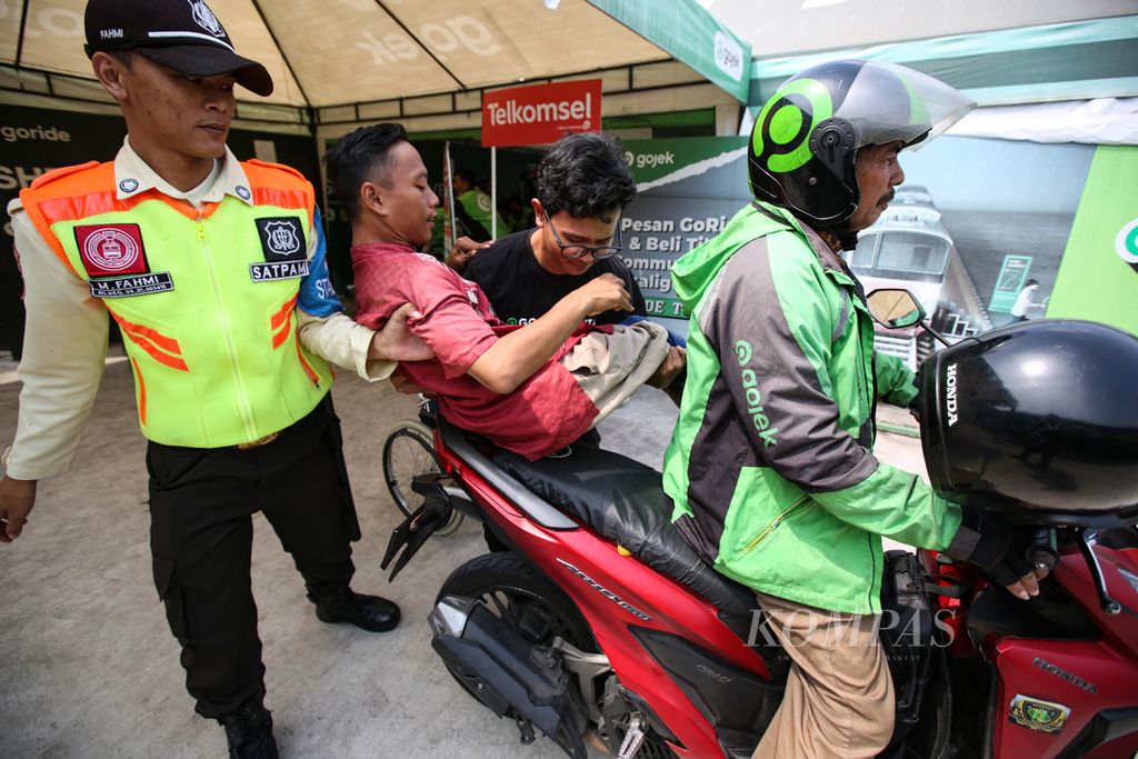 Petugas membantu penumpang disabilitas naik ke atas sepeda motor ojek<i> online </i>di shelter dekat Stasiun Palmerah, Jakarta, Jumat (30/8/2024). 