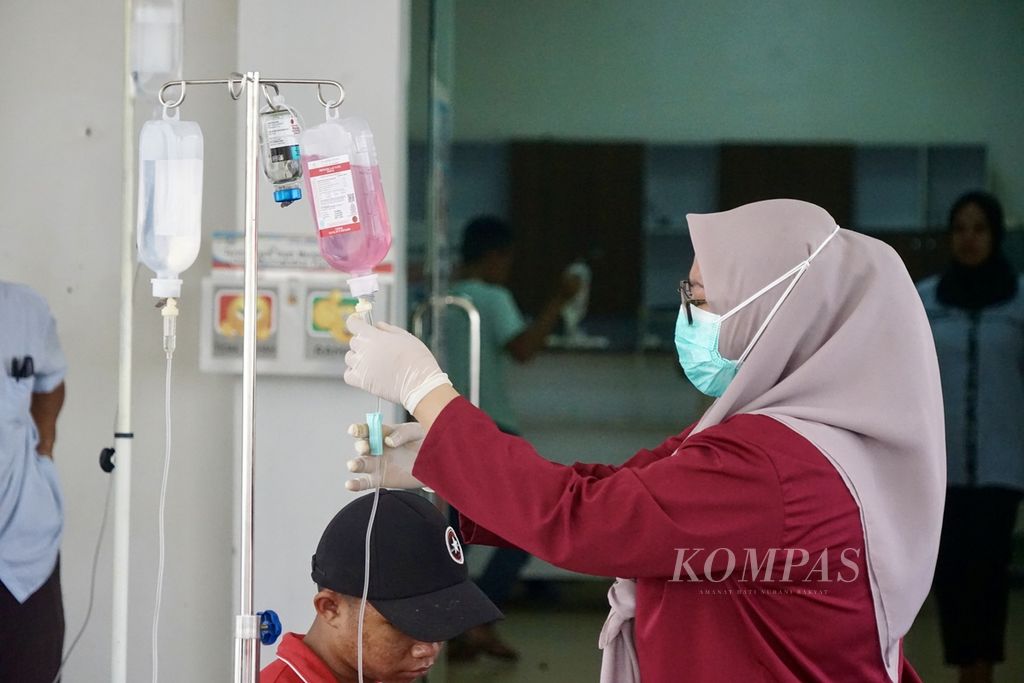  Perawat memasukkan obat ke infus di selasar IGD RSUD Kendari, Sulawesi Tenggara, Senin (25/3/2024). Pasien DBD membeludak dan memenuhi RS ini. Total ada 16 pasien meninggal di Sultra akibat penyakit yang menular melalui nyamuk ini.