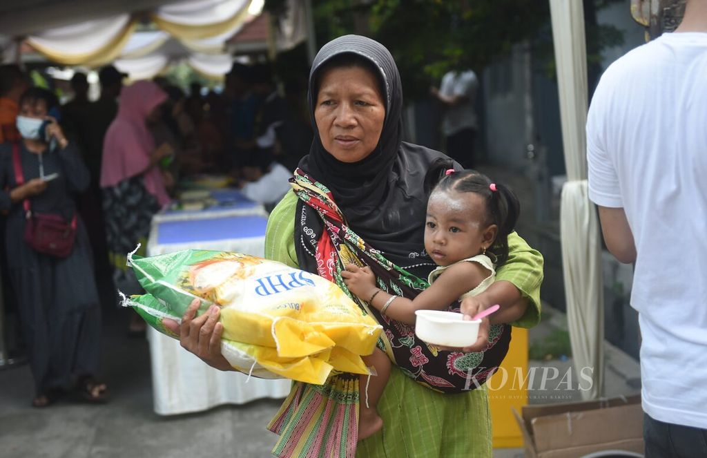 Warga membawa beras yang dibeli saat Gerakan Pangan Murah di Rusunawa Tanah Merah, Surabaya, Senin (1/4/2024). Gerakan Pangan Murah dilakukan secara serentak di seluruh Indonesia. 