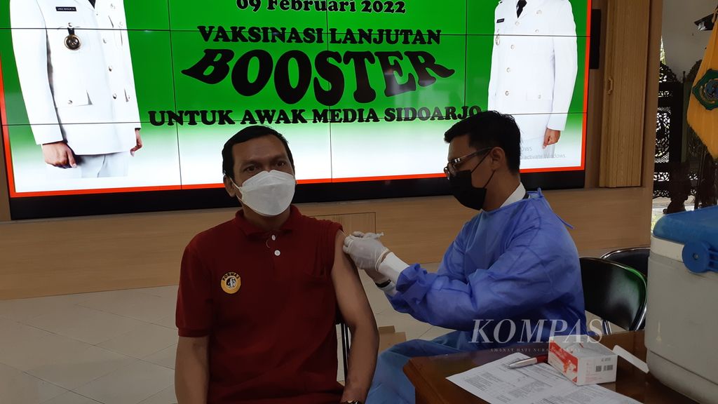 Seorang wartawan yang bertugas di Sidoarjo, Jawa Timur, menerima vaksin dosis penguat di Pendopo Kabupaten Sidoarjo, Rabu (8/2/2022).