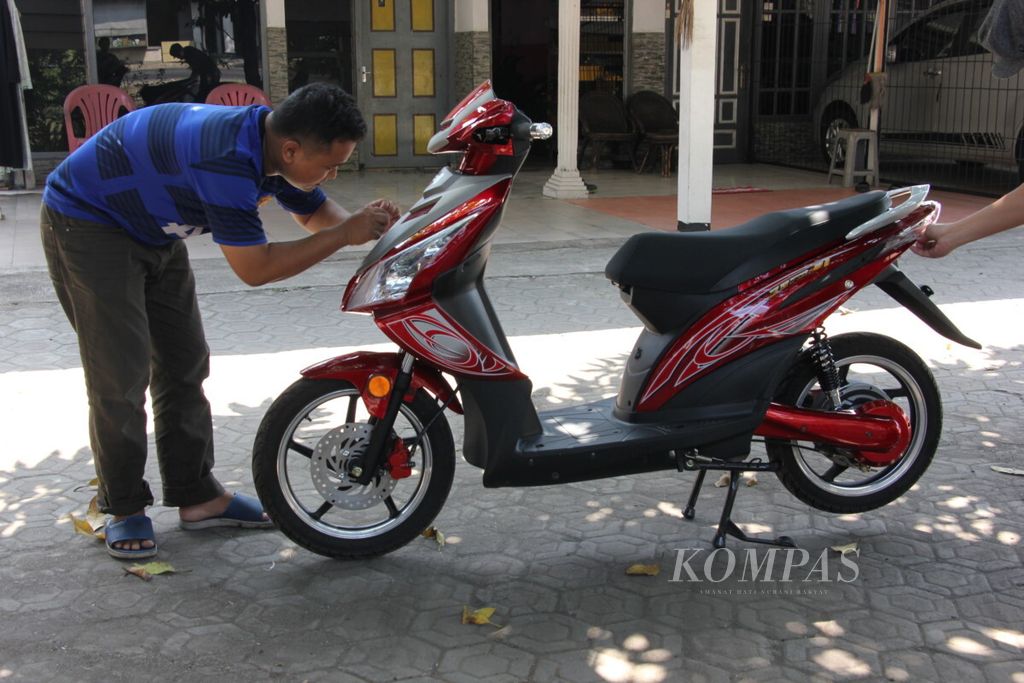 Pegawai PT Wim Motor memeriksa sepeda motor listrik rakitannya di Kabupaten Gresik, Jawa Timur, Jumat (20/7/2018). Sepeda motor listrik yang diimpor dari China itu telah dipasarkan di Agats, Kabupaten Asmat, Papua, sejak 2009.
