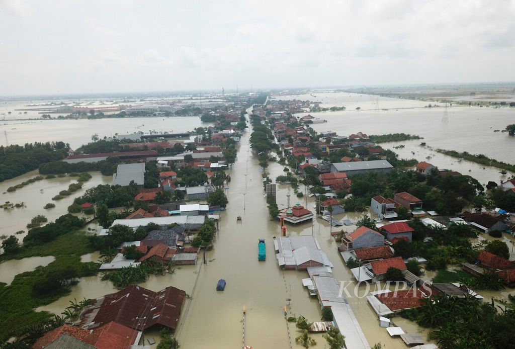 Floods have cut off the main access road of the Demak-Kudus Pantura route after the embankment of the Wulan River broke in Karanganyar district, Demak regency, Central Java, on Monday (12/2/2024).
