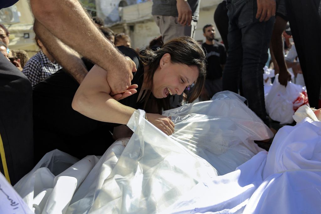 Seorang wanita Palestina meratapi jenazah kerabatnya yang tewas dalam serangan udara Israel yang menghantam gereja Ortodoks Yunani, di kota Gaza, 20 Oktober 2023.