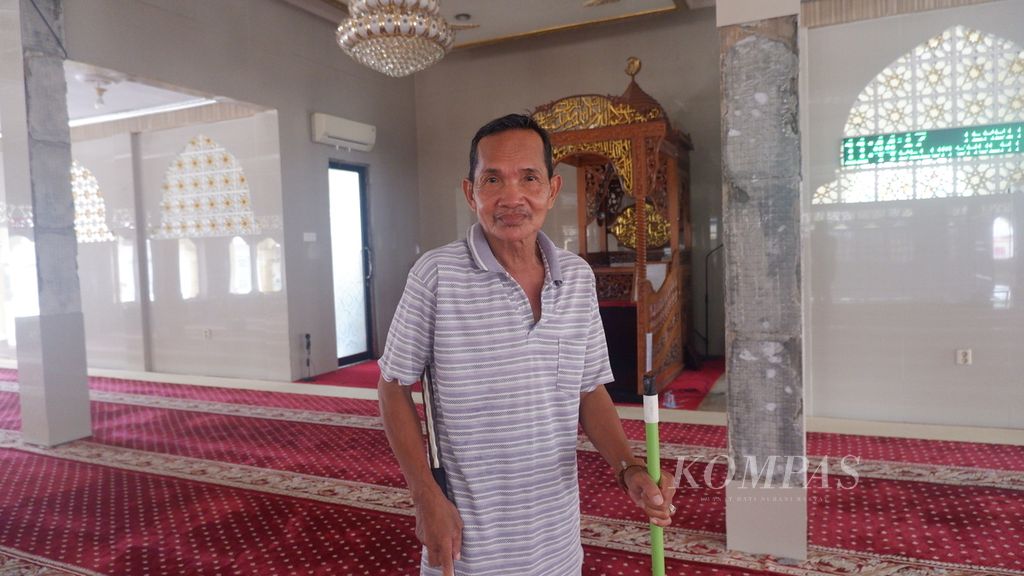 Suriansyah (57), marbot atau kaum masjid, membersihkan karpet di Masjid Al-Amin, Banua Anyar, Banjarmasin, Kalimantan Selatan, Kamis (21/3/2024).