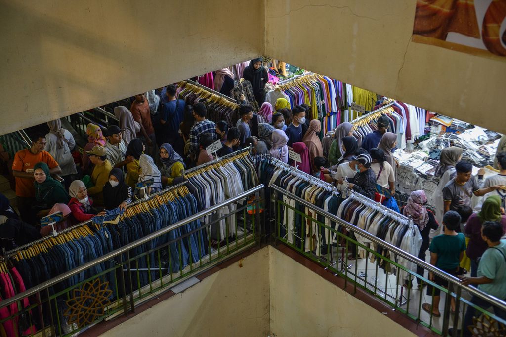 Hiruk-pikuk warga saat memilih pakaian yang akan dibelinya di Pasar Tanah Abang, Jakarta Pusat, Minggu (9/4/2023). 