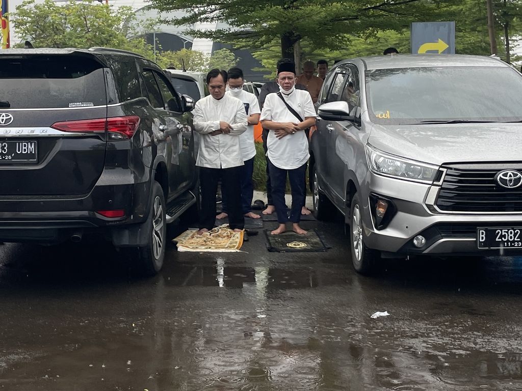 Jemaah Muhammadiyah melaksanakan shalat Idul Fitri memanfaatkan ruang kosong di antara dua mobil yang terparkir di halaman Jakarta Equestrian Park, Pulomas, Jakarta Timur, Jumat (21/4/2023).