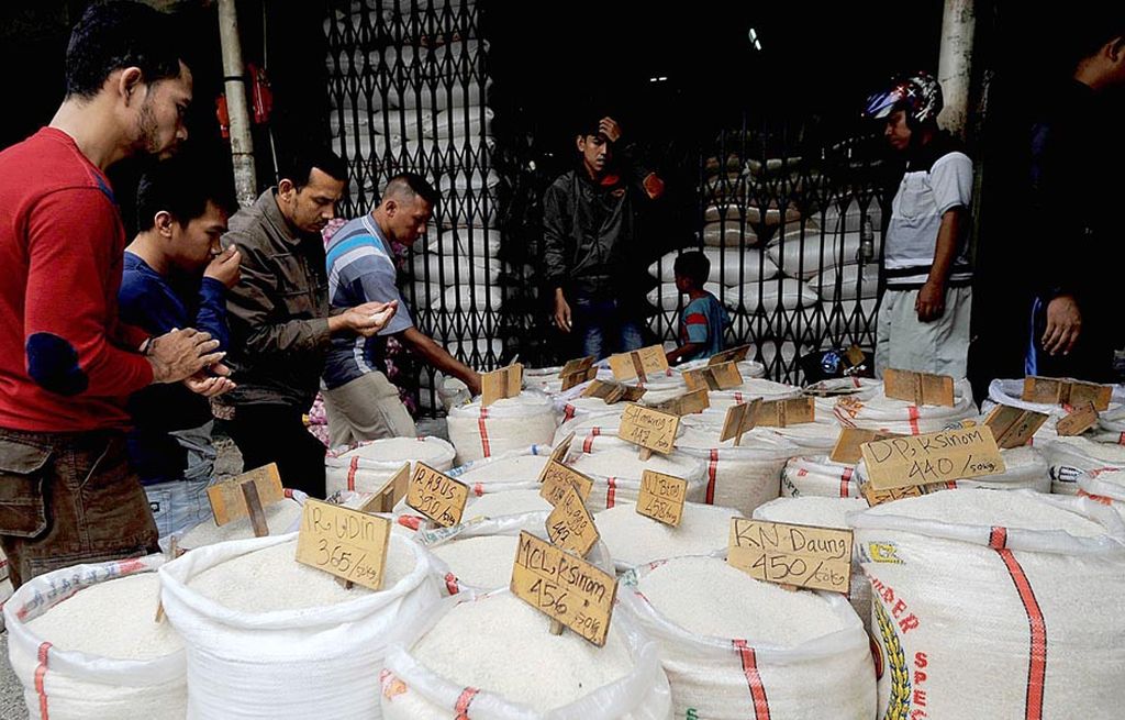 Pembeli memilih berbagi jenis beras yang dijual di Pasar Induk Beras Cipinang, Jakarta Timur, Minggu (23/7). Pemerintah berupaya untuk memotong rantai distribusi beras untuk menekan harga di tingkat konsumen.