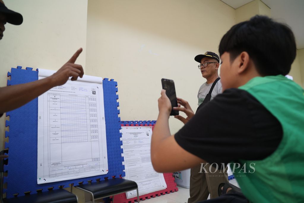 Anggota Panitia Pemilihan Kecamatan (PPK) mendokumentasikan hasil rekapitulasi surat suara Pemilu 2024 tingkat kecamatan di GOR Cilandak, Jakarta Selatan, Senin (20/2/2024). 