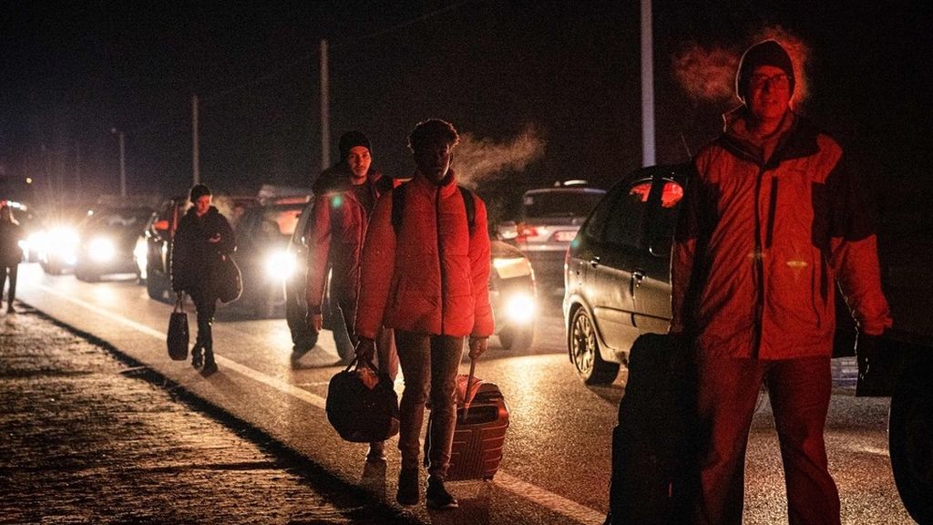 Warga mengungsi dengan berjalan kaki ataupun naik kendaraan dari Ukraina menuju Polandia melalui pintu perbatasan Korczowa-Krakovets, Sabtu (26/2/2022), untuk menyelamatkan diri dari pertempuran menyusul serangan Rusia ke Ukraina. 