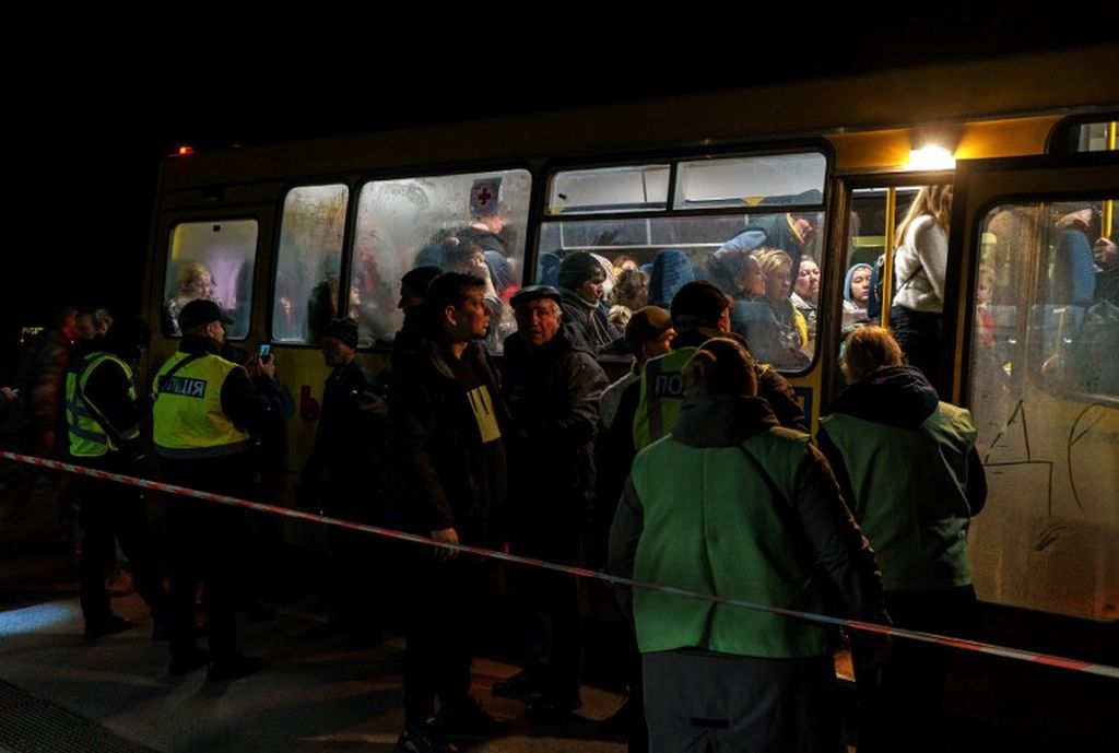Penumpang bersiap turun dari bus yang mengevakuasi mereka dari Mariupol ke Zaporizhzhia, Minggu (1/5/2022). Ada 30 bus yang mengungsikan warga sipil Ukraina melalui jalur kemanusiaan yang disepakati oleh Pemerintah Rusia.   