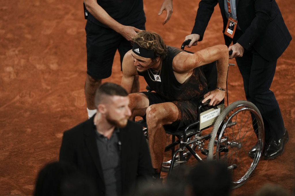 Petenis Jerman, Alexander Zverev, duduk di kursi roda setelah mengalami cedera ligamen saat babak final Perancis Terbuka di Roland Garros, Paris, Jumat (3/6/2022). Pertandingan dihentikan pada set kedua setelah Zverev tidak mampu bertanding karena cedera parah.