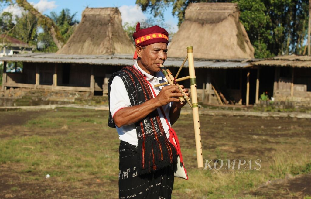Marselus Selu (64) meniup <i>foy doa</i>, alat musik tradisional Ngada yang terbuat dari bambu, di Kampung Adat Wogo, Desa Ratogesa, Kecamatan Golewa, Kabupaten Ngada, Nusa Tenggara Timur, Rabu (22/6/2022).