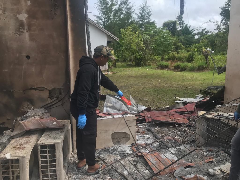 Aparat kepolisian melakukan olah tempat kejadian perkara di kantor KPU Kabupaten Yahukimo, Papua Pegunungan, yang terbakar pada Minggu (6/8/2023).