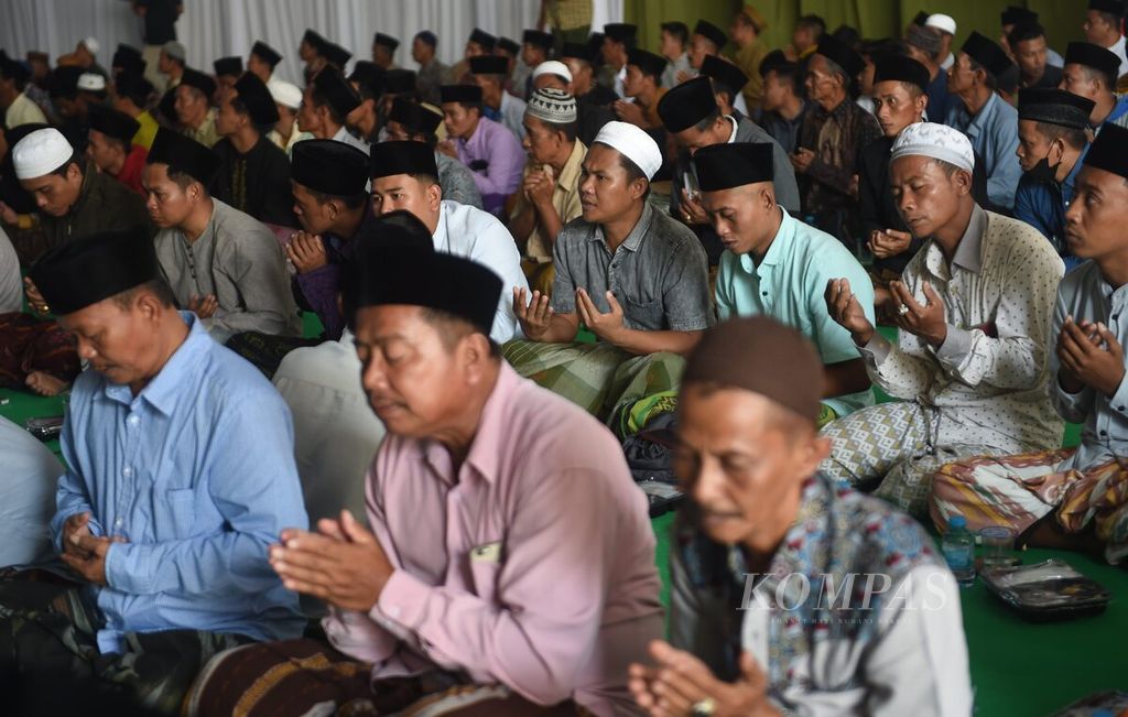 Warga berdoa saat tasyakuran kedatangan dari ibadah haji keluarga besar Khoirul Umam di Kabupaten Pamekasan, Jawa Timur, Senin (17/7/2023).  