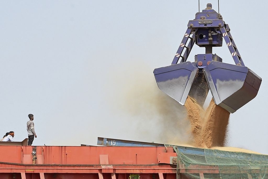 Pekerja menyaksikan proses pemuatan gandum ke kapal di pelabuhan Deendyal Port Authority di Kandla, di Negara Bagian Gujarat, India, Rabu (18/5/2022). India sebagai produsen gandum terbesar kedua dunia mengeluarkan kebijakan larangan ekspor sejak Jumat (13/5/2022).