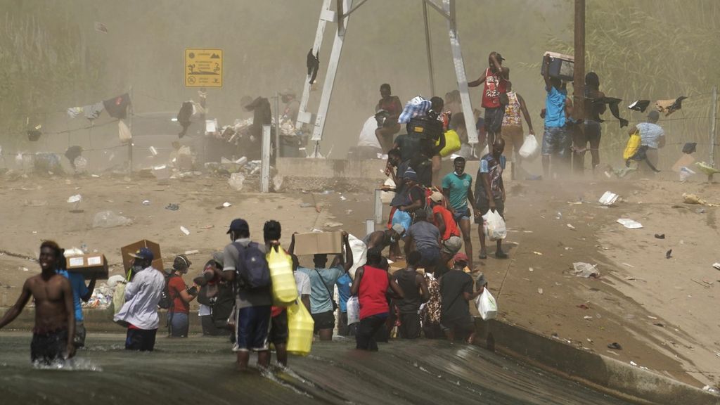 Warga imigran yang sebagian besar berasal dari Haiti menerobos badai debu saat berusaha menyeberangi Sungai Rio Grande untuk memasuki wilayah Texas, Amerika Serikat, dari Meksiko. 