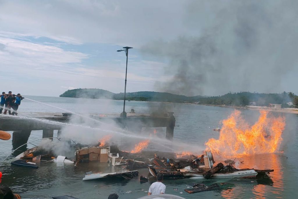 Petugas kepolisian berusaha memadamkan api yang membakar <i>speedboat</i> milik calon gubernur Maluku Utara, Benny Laos, di dermaga Pelabuhan Regional Bobong, Desa Bobong, Kabupaten Pulau Taliabu, Maluku Utara, Sabtu (12/10/2024). Pihak RSUD Bobong, Kabupaten Pulau Taliabu, Maluku Utara, menyatakan, cagub Maluku Utara, Benny Laos, meninggal dunia setelah dilakukan penanganan medis seusai menjadi korban terbakarnya <i>speedboat</i> yang ditumpangi. 