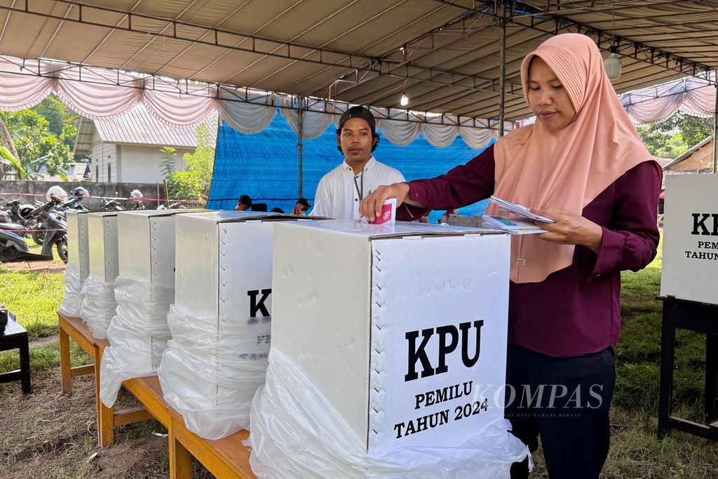 Petugas mendampingi warga saat memasukkan surat suara seusai mencoblos pada pemungutan suara ulang di TPS 12 Desa Sigar Penjalin, Kecamatan Tanjung, Kabupaten Lombok Utara, Nusa Tenggara Barat, Rabu (21/2/2024).