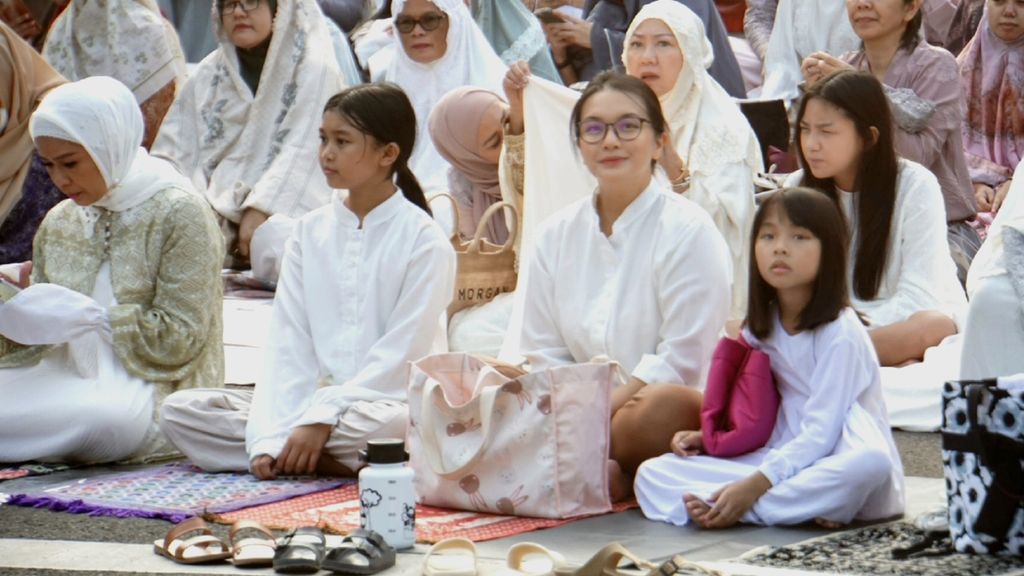 Seorang perempuan dan keluarganya mendengarkan khotbah saat shalat Idul Fitri 1444 Hijriah di Masjid Agung Sunda Kelapa, Menteng, Jakarta, Sabtu (22/4/2023).