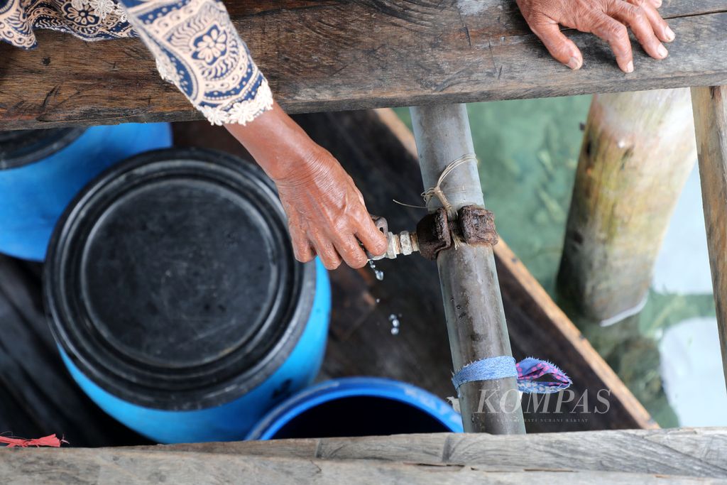 Warga menunjukkan kecilnya aliran air dari pipa PDAM di Kampung Bajo Torosiaje, Popayato, Kabupaten Pohuwato, Provinsi Gorontalo, Jumat (15/7/2022). Dalam dua bulan terakhir, masyarakat yang tinggal atas laut ini mengeluhkan tidak lancarnya aliran air bersih dari PDAM. Paling parah dialami masyarakat yang tinggal di bagian belakang atau ujung desa. Setiap hari mereka harus mengambil air dari rumah yang ada di bagian depan desa. Sebagian bahkan harus menampung air hujan atau membeli air bersih ke darat. 