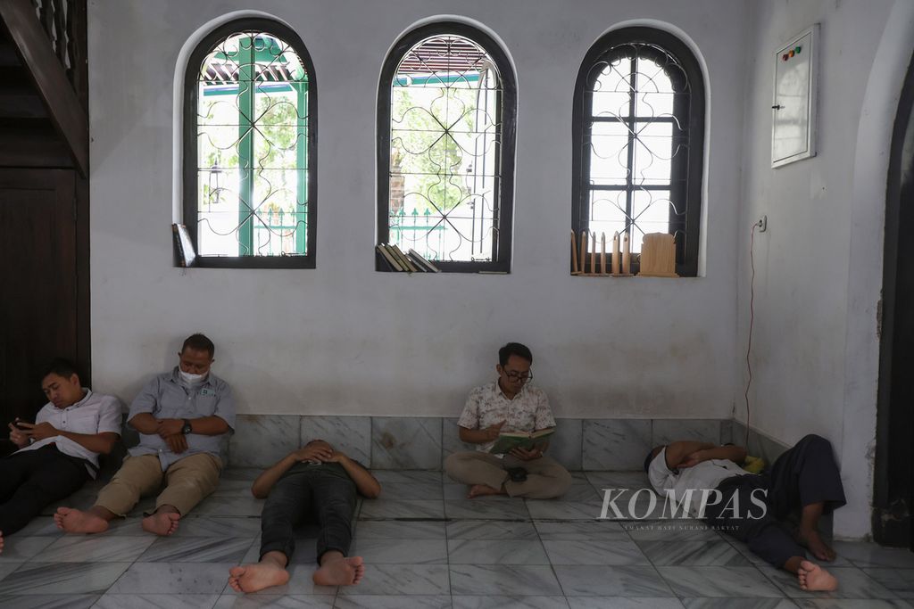 Sejumlah warga beristirahat dan membaca Al Quran untuk menunggu waktu berbuka puasa di Masjid Jami Al Makmur, Jalan Raden Saleh, Cikini, Jakarta Pusat, Kamis (21/3/2024). 