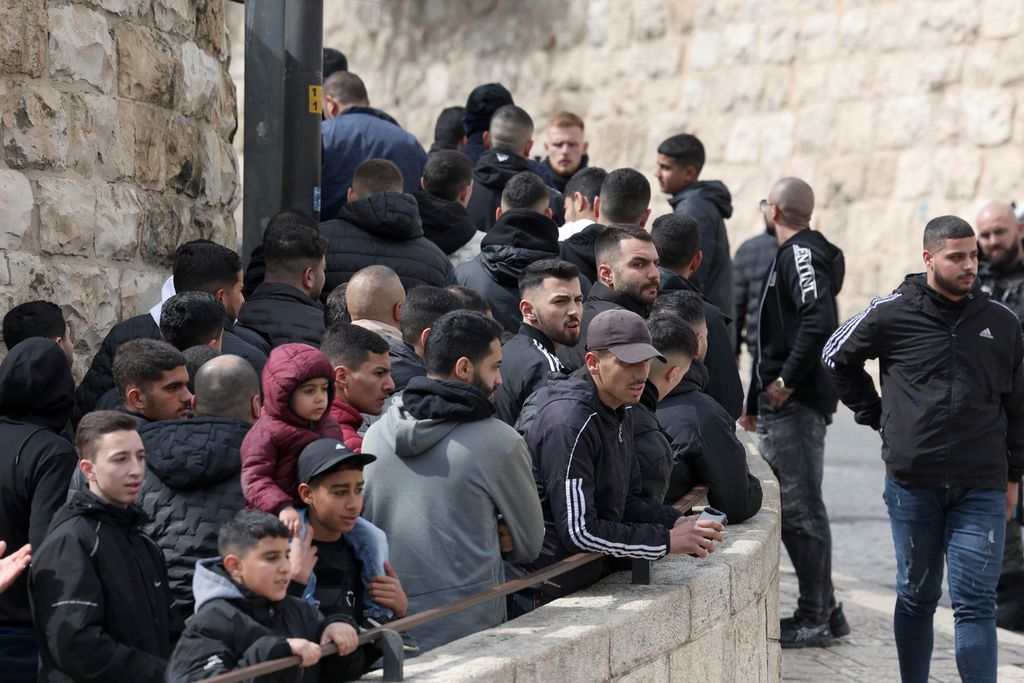 Jemaah muslim Palestina menunggu di pos pemeriksaan Israel dekat Gerbang Singa untuk memasuki kompleks Masjid Al-Aqsa sebelum shalat Jumat di Jerusalem pada 16 Februari 2024.