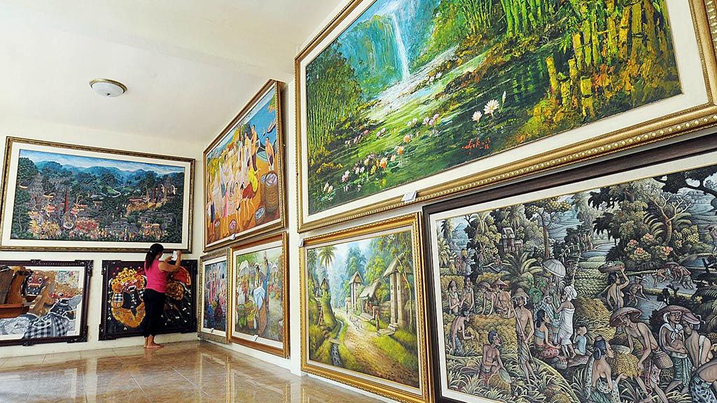 Widi (41) memeriksa beberapa lukisan yang ada digaleri miliknya, Manacika, di Desa Penestanan, Ubud, Bali. 