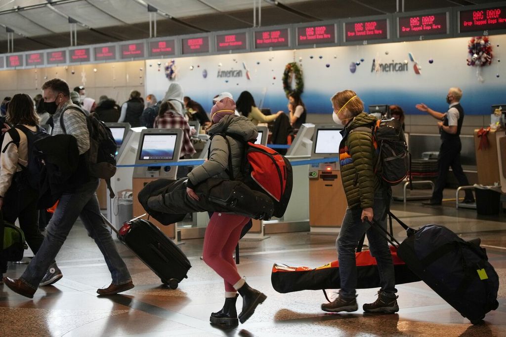 Penumpang antre di konter check-in maskapai American Airlines di Bandara Internasional Denver, Colorado, Amerika Serikat (26/12/2021). Lonjakan penularan varian Omicron membuat frekuensi penerbangan dikurangi.