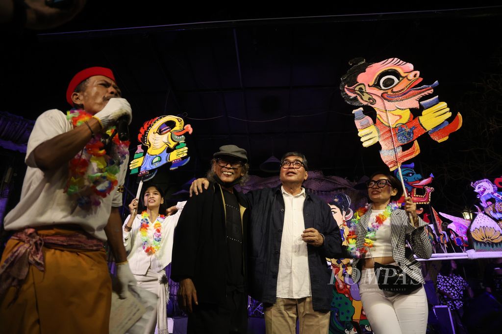 Seniman Ampun Sutrisno (kiri) menampilkan pertunjukan wayang tentang penulis Sindhunata (kanan) dan pensiunan wartawan Thomas Pudjo (tengah) dalam pembukaan pameran ”Kita Berteman Sudah Lama” di Bentara Budaya Yogyakarta, Kotabaru, Yogyakarta, Sabtu (20/5/2023) malam. 