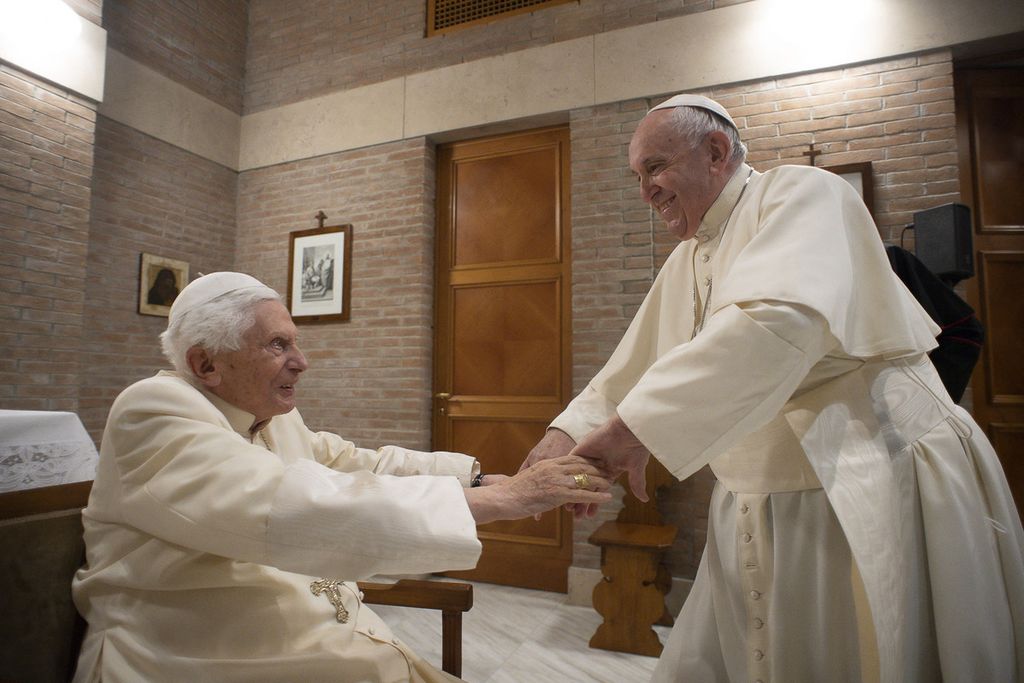 Dalam foto yang diambil pada 28 November 2020 ini tampak Paus Fransiskus menyapa akrab Paus Emeritus Benediktus XVI menjelang konsistori untuk 13 kardinal baru. 