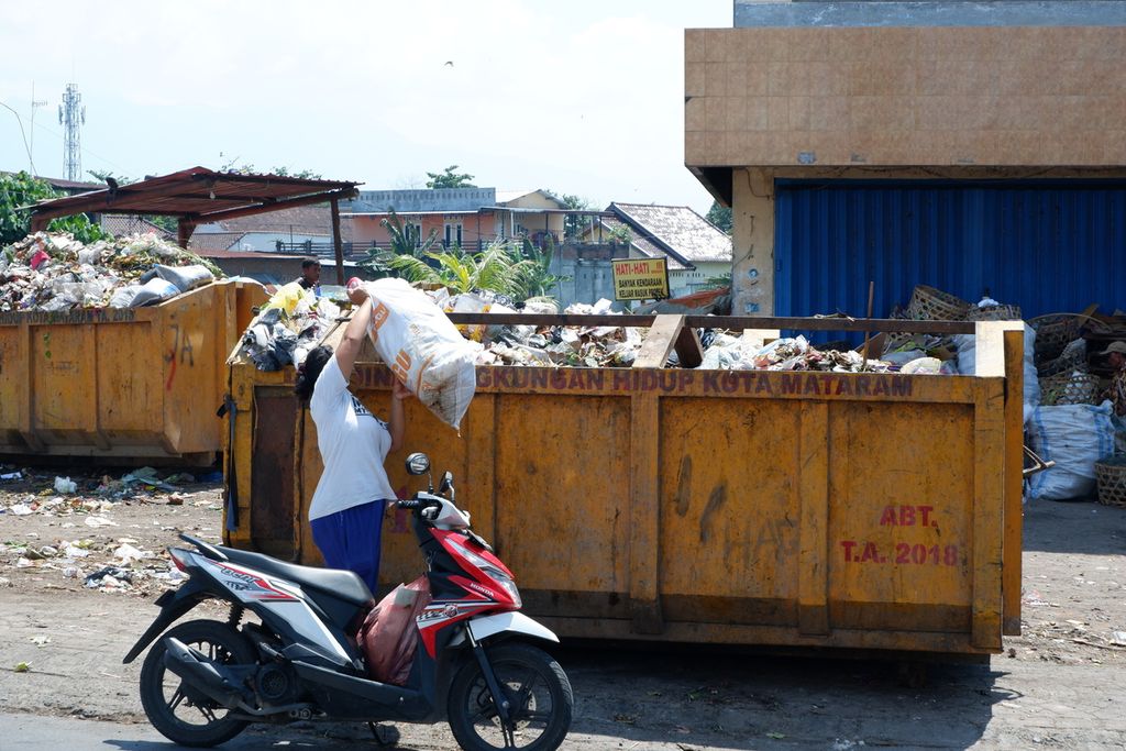 Warga menaikkan sampah ke penampungan sampah di tempat pembuangan sampah di kawasan Jalan Yos Sudarso, Mataram, NTB, Selasa (13/10/2020).