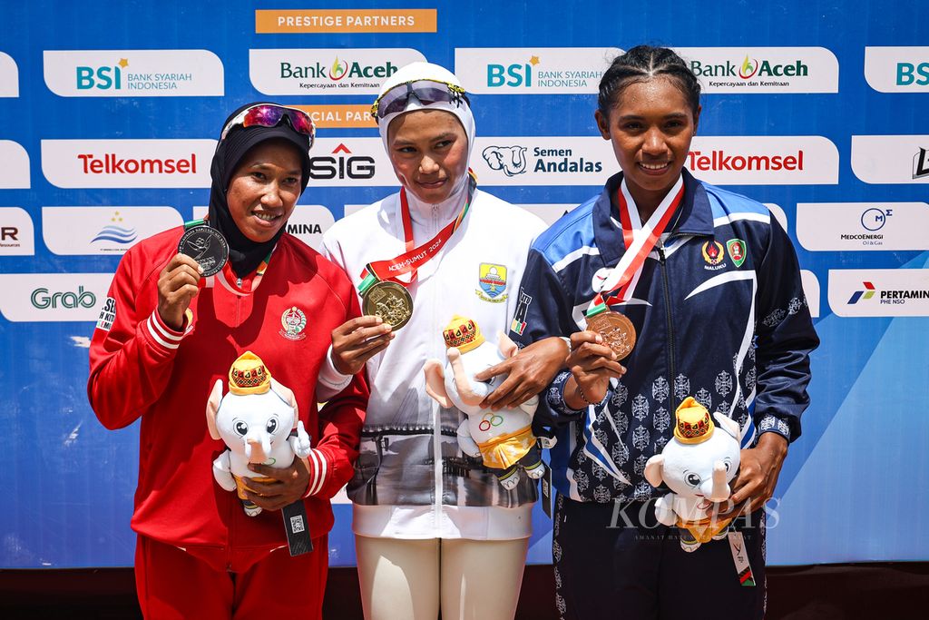 Atled dayung Sulawesi Selatan, Nurtang; atlet dayung Jambi, Mutiara Rahma Putri; dan atlet dayung Maluku, Issa Behuku (dari kiri ke kanan); menerima medali cabang dayung rowing nomor single sculls dalam PON Aceh-Sumut 2024 di Waduk Keuliling, Aceh Besar, Aceh, Kamis (12/9/2024). 