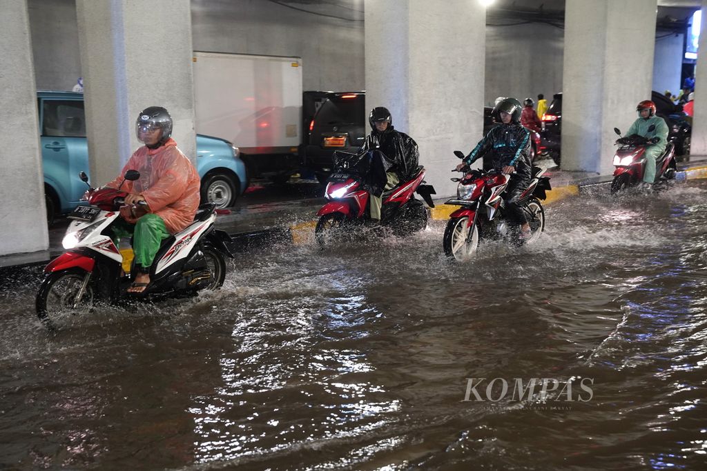 Pengendara melintasi genangan air di kolong Jalan Galunggung, Jakarta Selatan, Kamis (11/1/2024). 