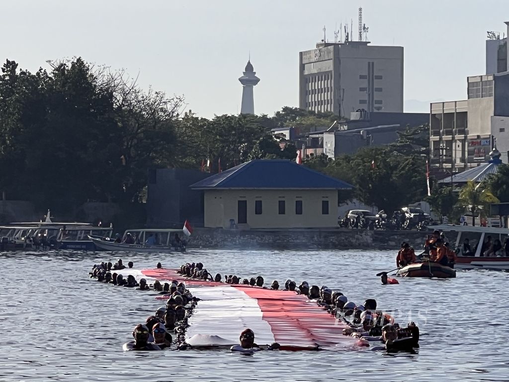 Para perenang meninggalkan dermaga penyeberangan Ditpilairud Polda Sulsel menuju Pulau Gusung dengan mengarak bendera Merah Putih dan baliho sepanjang 78 meter, Sabtu (12/8/2023).