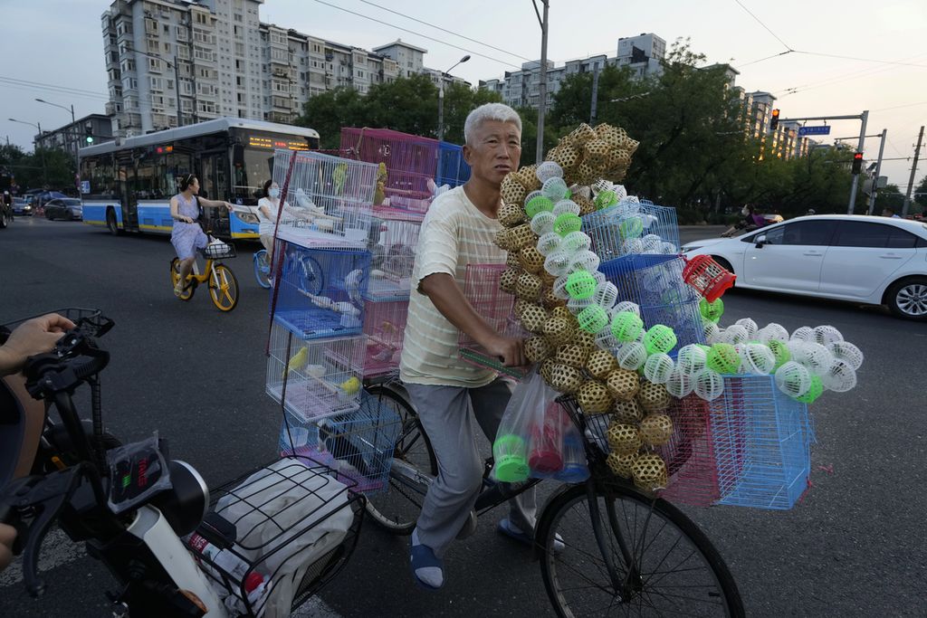 Penjual keliling menjajakan burung dan jangkrik di sebuah jalan di Beijing, China, 15 Agustus 2023. Presiden Xi Jinping menyerukan agar rakyat sabar menantikan pembenahan perekonomian. 