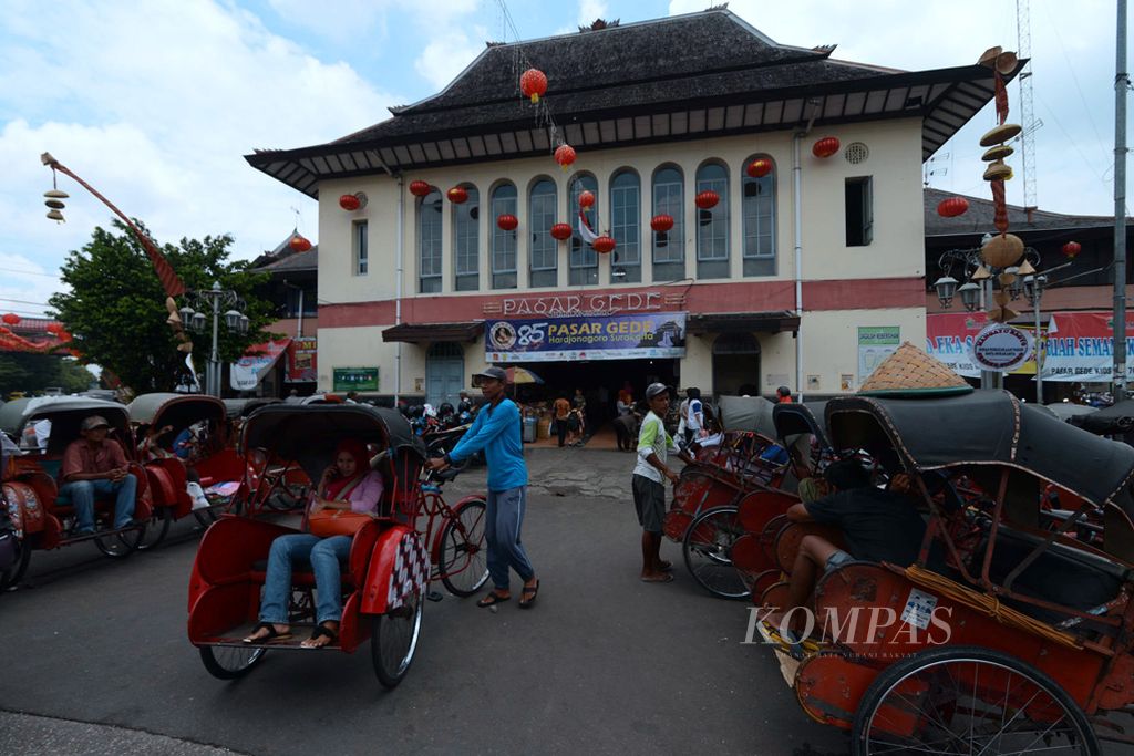 Pasar Gede Solo - Pengemudi becak mengantarkan penumpang setelah berbelanja di Pasar Gede, Kota Solo, Jawa Tengah, Rabu (11/2/2015). Pasar Gede yang yang telah menginjak usia ke-85 sejak berdiri tahun 1930 menjadi salah satu ikon pariwisata Kota Solo.