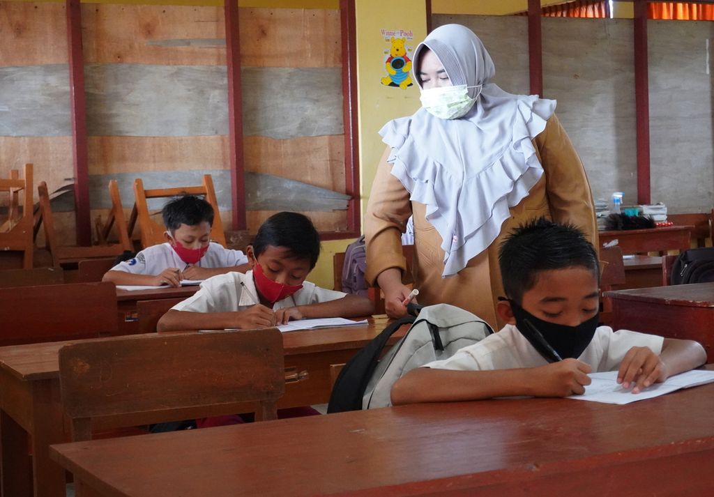 Guru memantau siswa belajar di SD Negeri Randu 01, Kecamatan Pecalungan, Kabupaten Batang, Jawa Tengah, pada hari pertama pembelajaran tatap muka, Selasa (9/3/2021). Setelah penerapan pemberlakuan pembatasan kegiatan masyarakat berskala mikro berakhir, Pemerintah Kabupaten Batang memutuskan untuk kembali menggelar pembelajaran tatap muka bagi sekolah yang berada di desa yang berstatus sebagai zona hijau atau nol kasus Covid-19. Pembelajaran tatap muka di Batang merupakan yang pertama di Jateng.