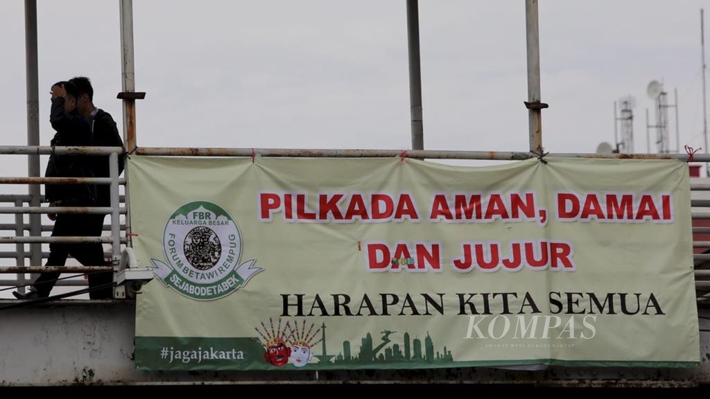 Sebuah spanduk imbauan kepada seluruh elemen masyarakat untuk menciptakan kondisi yang aman dan damai terpasang di kawasan Kramat, Jakarta, 7 April 2017. 