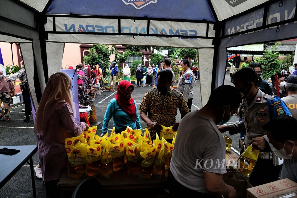 Warga antre membeli minyak goreng dengan harga Rp 14.000 per liter di halaman kantor Polsek Pesanggrahan, Jakarta Selatan, Jumat (4/3/2022). Setiap warga hanya dapat membeli maksimal empat liter minyak.