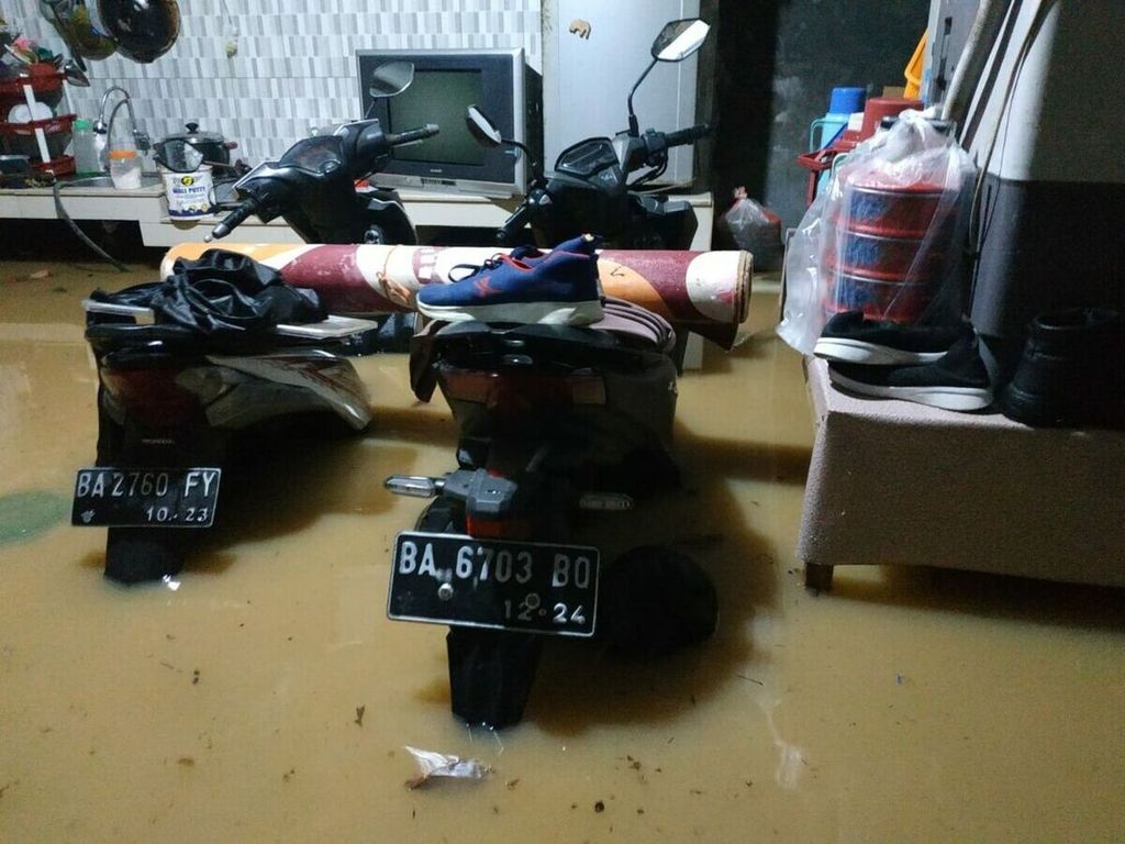 Sepeda motor dan perkakas di rumah warga terendam banjir di Palarik, Kelurahan Air Pacah, Kecamatan Koto Tangah, Padang, Sumatera Barat, Rabu (18/8/2021) malam.