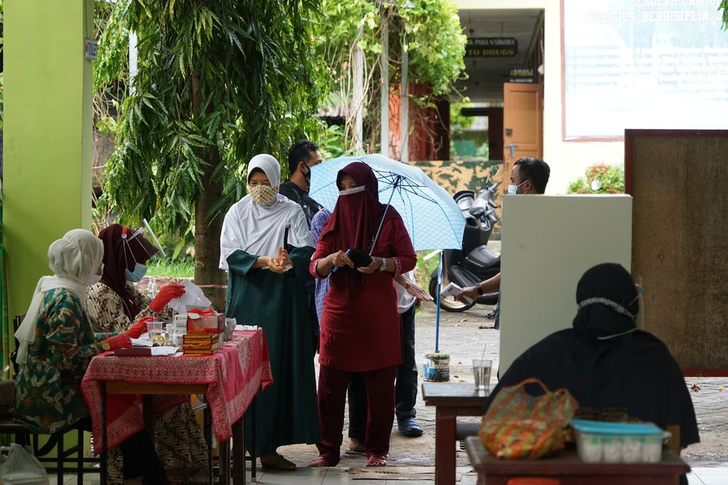 Calon pemilih berkumpul di pintu masuk TPS 24 di Tamalanrea, Makassar, Sulawesi Selatan, Rabu (9/12/2020). 