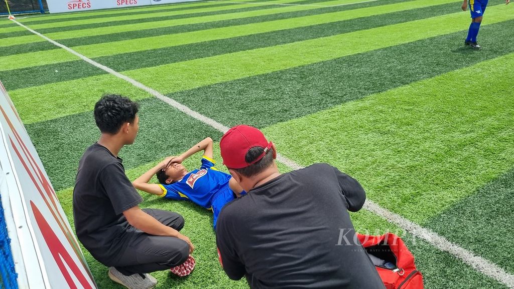 Bek Oneway Soccer School, Fazri Benzema, menjalani perawatan terhadap luka di lututnya pada laga Liga Kompas Kacang Garuda U-14, Sabtu (10/2/2024), di Lapangan Dewantara, Tangerang Selatan, Banten. Pada laga itu Oneway tumbang, 0-3, dari Intan Soccer Cipta Cendikia.